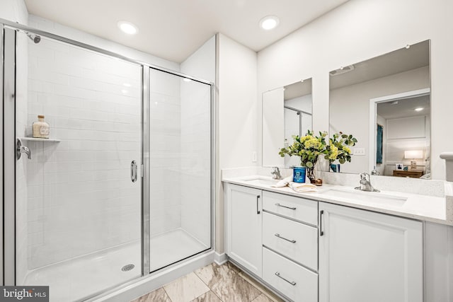 bathroom with a shower with door and vanity