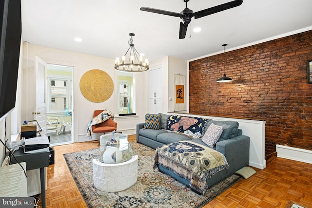 living room featuring parquet flooring, brick wall, and ceiling fan with notable chandelier