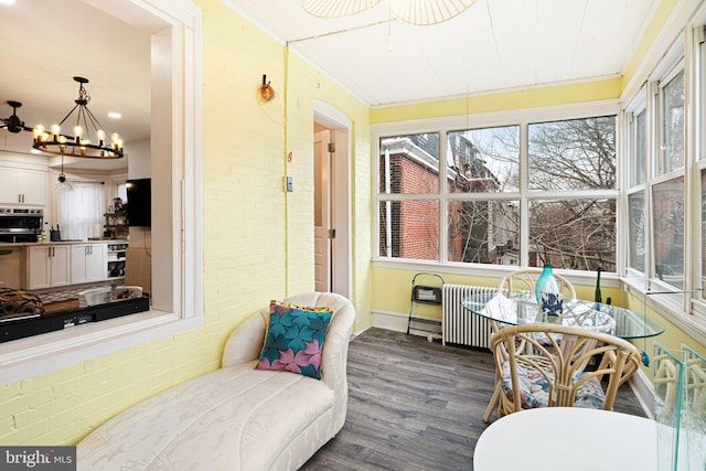 sunroom / solarium featuring a healthy amount of sunlight and an inviting chandelier