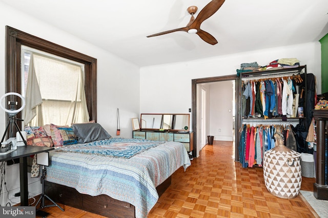 bedroom with ceiling fan, parquet flooring, and a closet