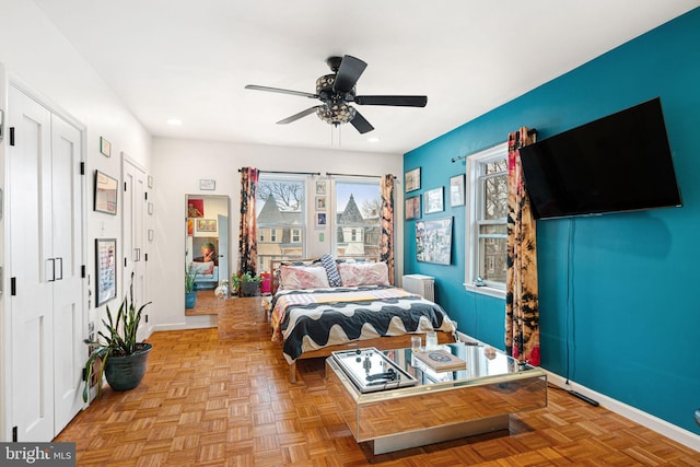 bedroom with ceiling fan, radiator heating unit, and light parquet floors