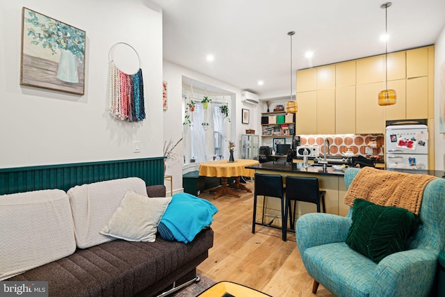 living room featuring light hardwood / wood-style floors and a wall mounted AC