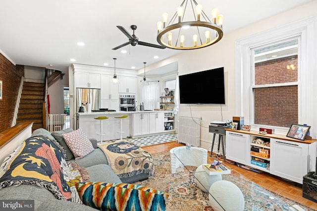 living room with light parquet floors, brick wall, and ceiling fan