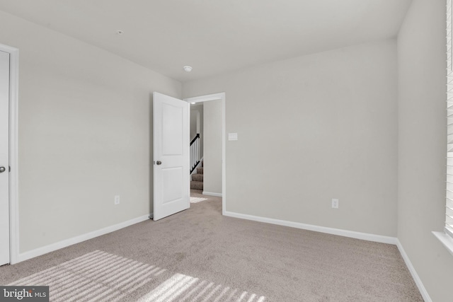 spare room featuring light colored carpet