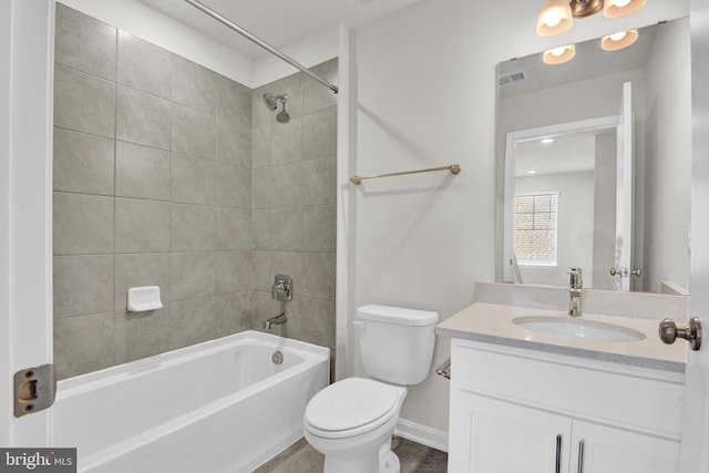 full bathroom featuring tiled shower / bath combo, vanity, and toilet