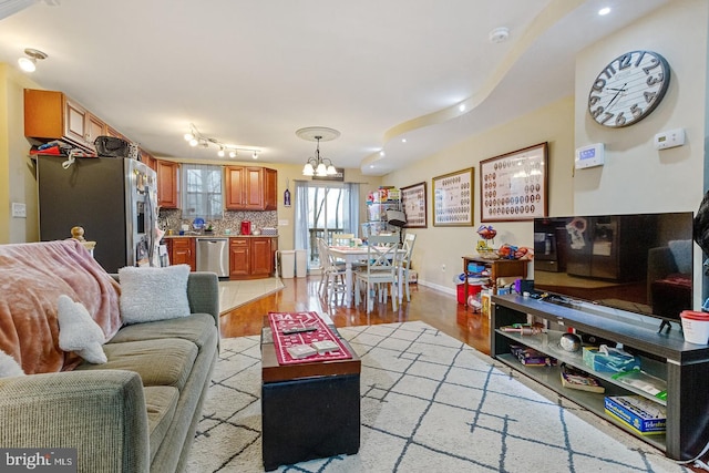 living room featuring an inviting chandelier and light hardwood / wood-style floors