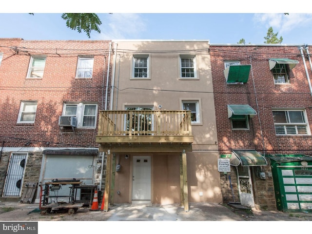 view of front of property with cooling unit and a balcony