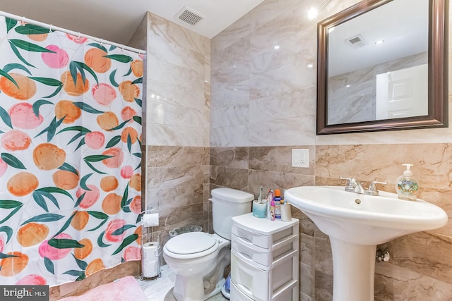 bathroom featuring tile walls, a shower with shower curtain, and toilet