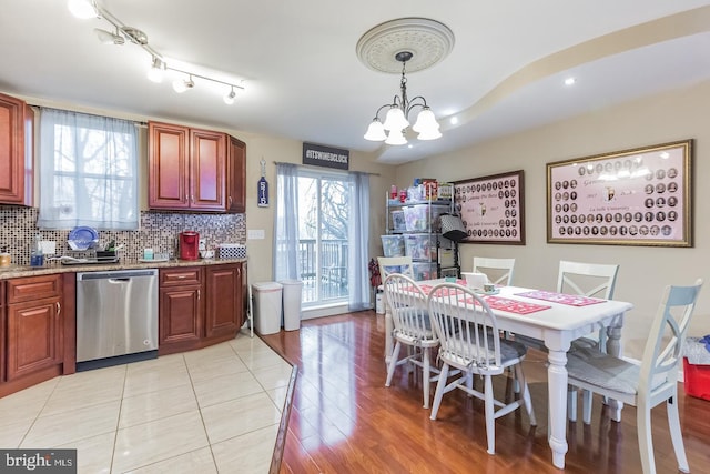 dining room with light wood-type flooring and a notable chandelier