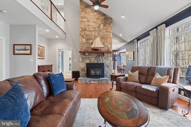 living area with a ceiling fan, light wood-style floors, a fireplace, high vaulted ceiling, and recessed lighting