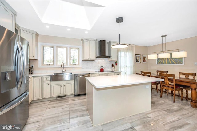 kitchen with wall chimney range hood, stainless steel appliances, a sink, and light countertops