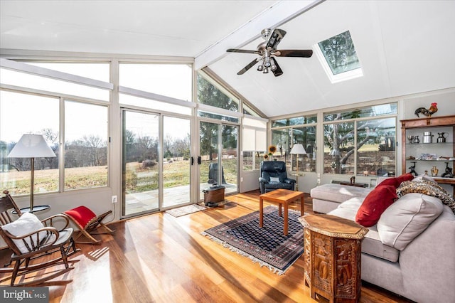 sunroom / solarium featuring ceiling fan and lofted ceiling with skylight