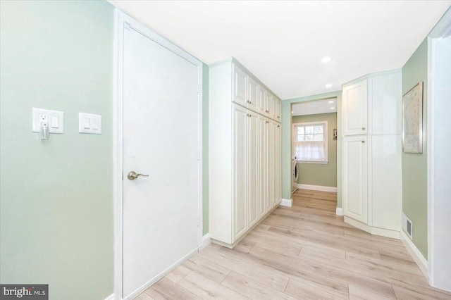 hall with light wood-type flooring, baseboards, visible vents, and recessed lighting