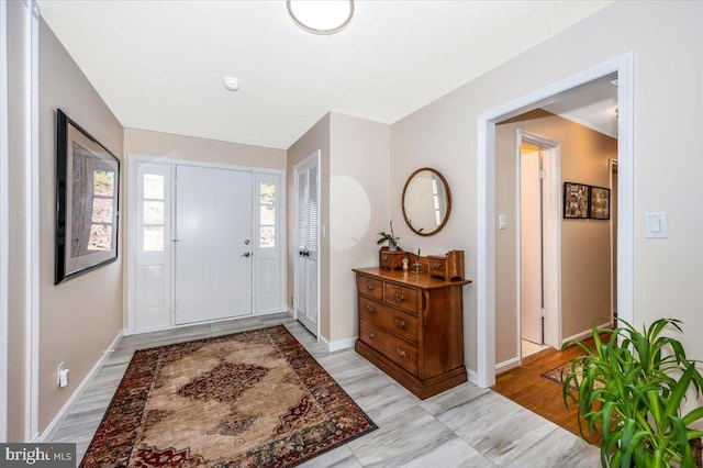 foyer featuring light wood-style flooring and baseboards