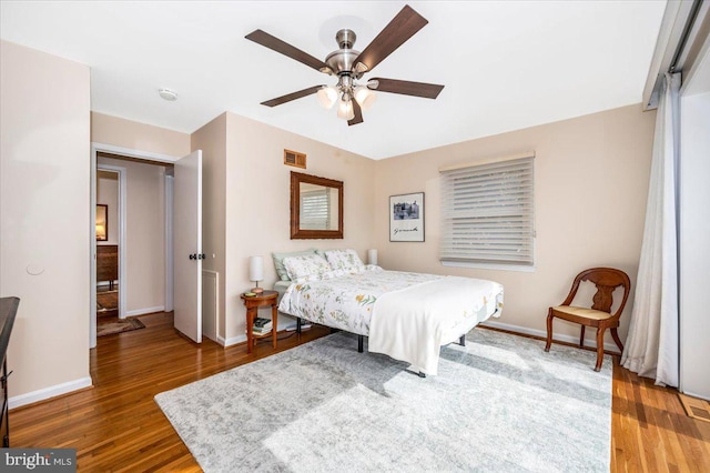 bedroom featuring baseboards, visible vents, and wood finished floors