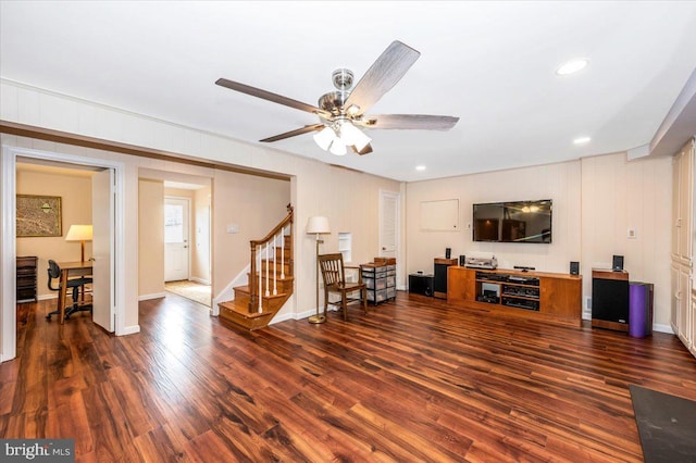 living area with baseboards, ceiling fan, stairway, and wood finished floors