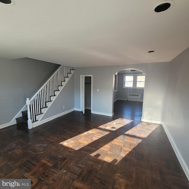 unfurnished living room with dark parquet flooring and a wall mounted AC