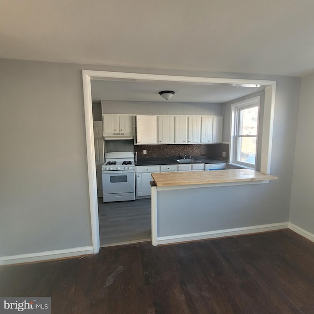 kitchen featuring sink, dark wood-type flooring, white cabinetry, tasteful backsplash, and white gas range