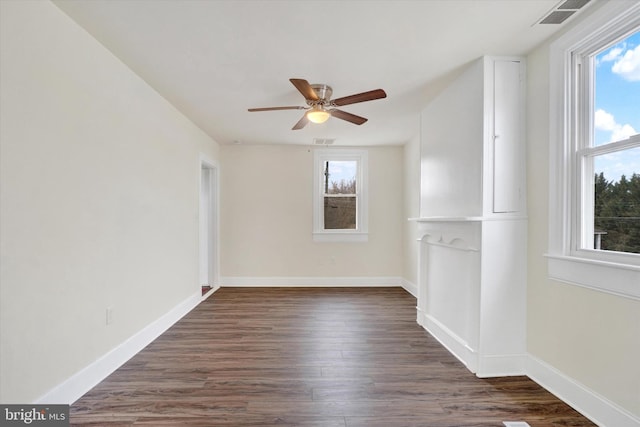 empty room featuring dark wood-type flooring and ceiling fan