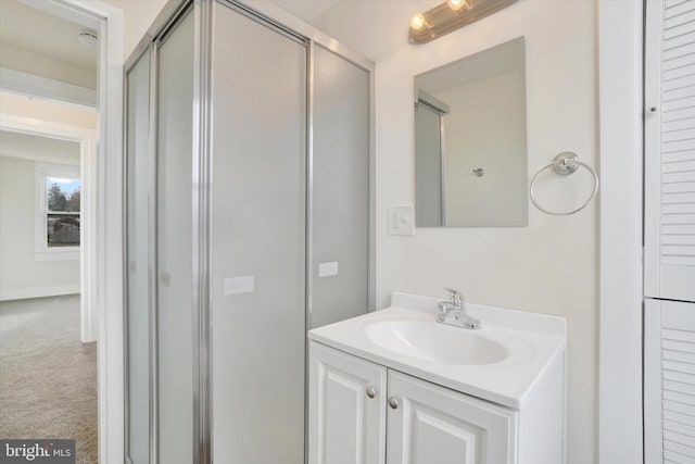 bathroom featuring vanity and a shower with door