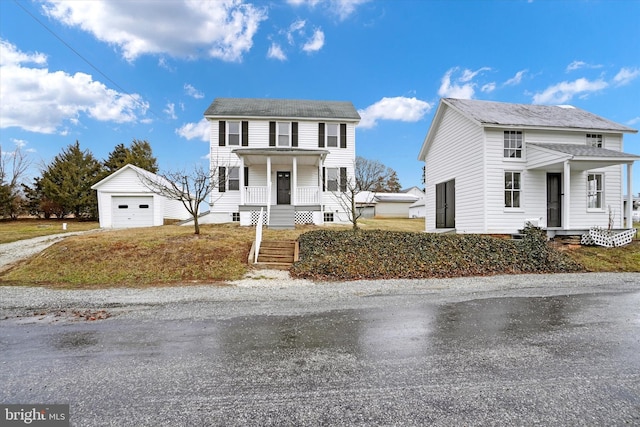 front of property featuring a garage, an outdoor structure, and covered porch