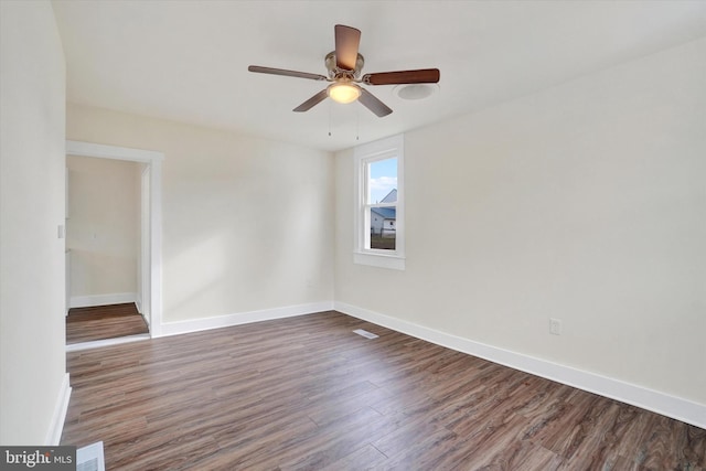 empty room featuring ceiling fan and dark hardwood / wood-style flooring