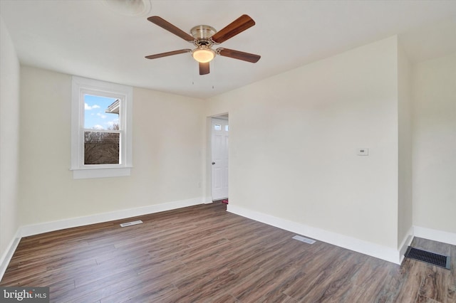 spare room featuring dark hardwood / wood-style floors and ceiling fan