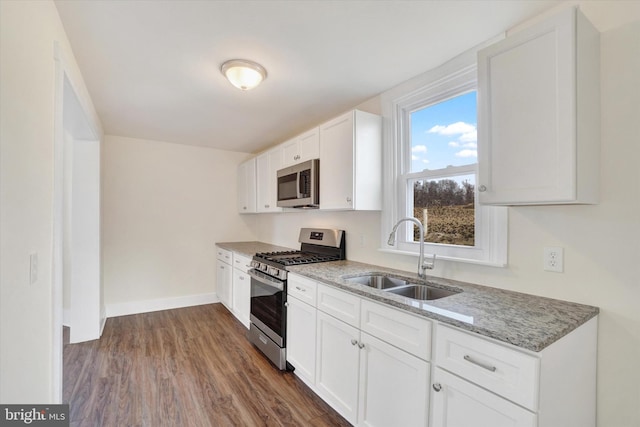 kitchen featuring white cabinetry, appliances with stainless steel finishes, sink, and light stone counters