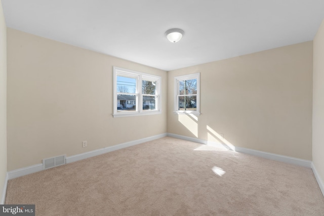 unfurnished room featuring light carpet