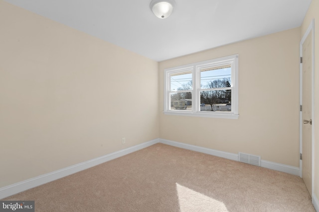 spare room featuring light colored carpet