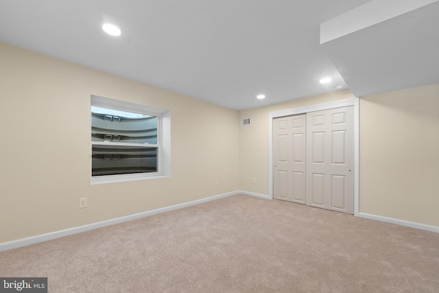 unfurnished bedroom featuring a closet and light carpet