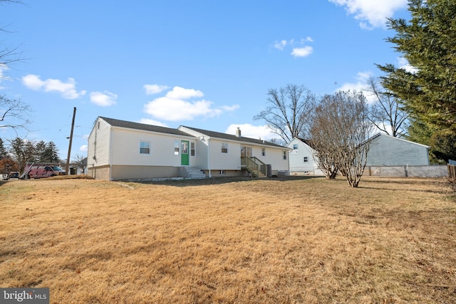 rear view of property featuring a lawn