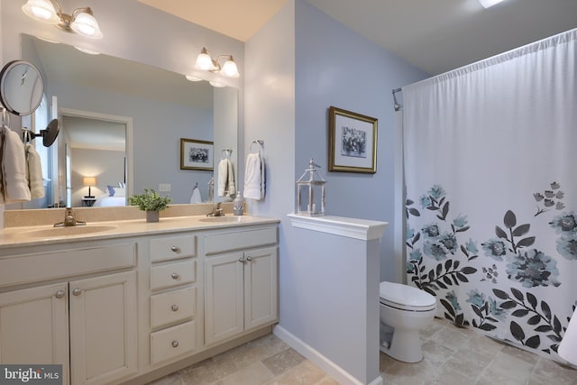 bathroom featuring vanity, toilet, and curtained shower