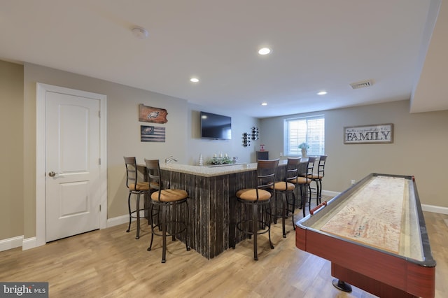 bar featuring light hardwood / wood-style floors