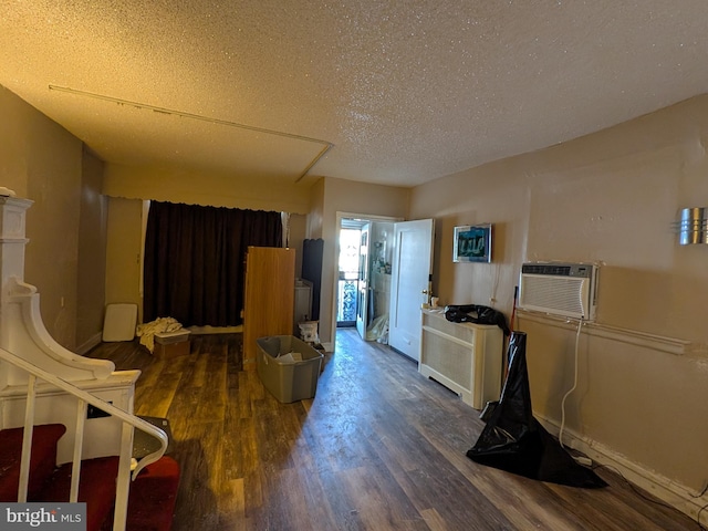 kitchen with dark wood-type flooring, a wall mounted AC, and a textured ceiling