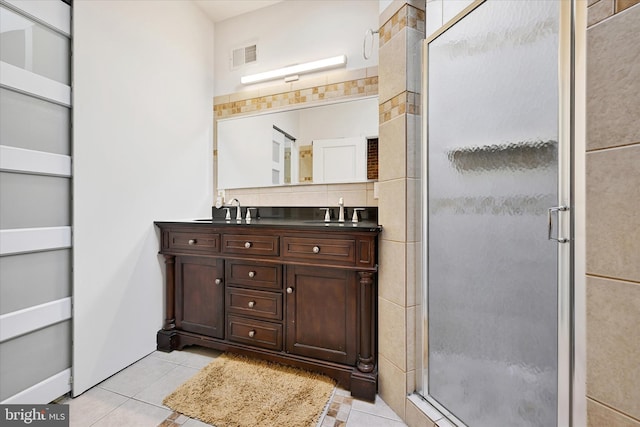 bathroom with decorative backsplash, tile patterned floors, a shower with shower door, and vanity