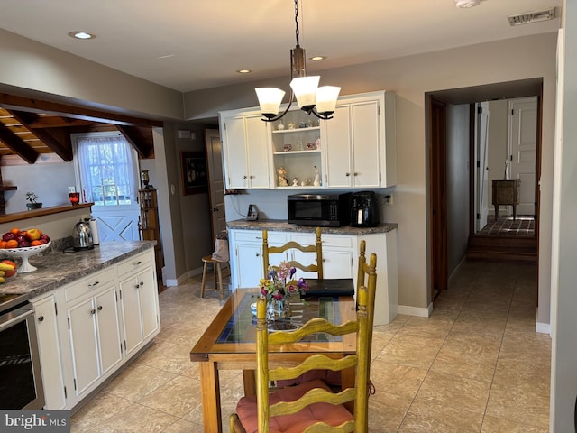 kitchen with white cabinetry, hanging light fixtures, stainless steel electric stove, and an inviting chandelier