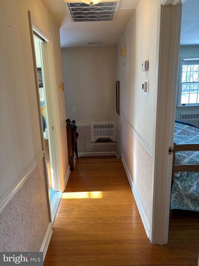 corridor with radiator and light hardwood / wood-style flooring