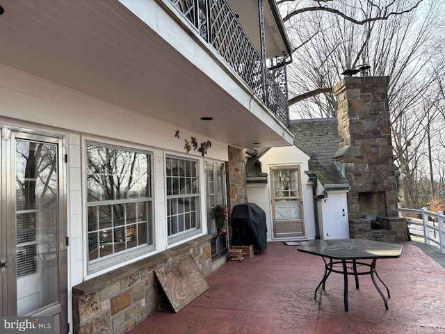 view of patio / terrace featuring area for grilling and an outdoor stone fireplace