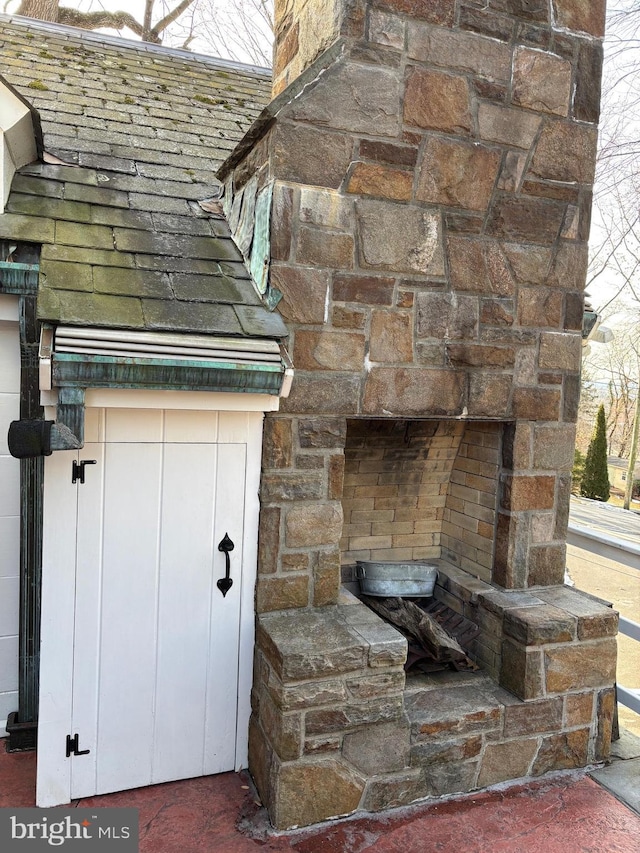 exterior details featuring an outdoor stone fireplace