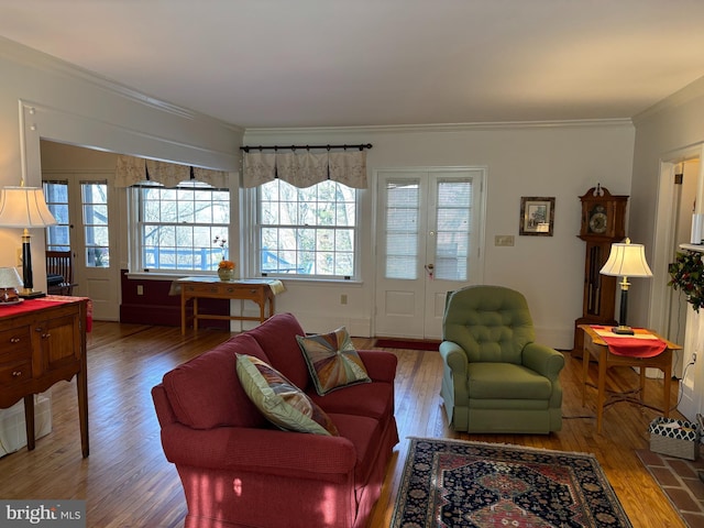 living room with hardwood / wood-style flooring, ornamental molding, and french doors