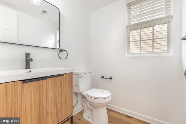 bathroom featuring vanity, wood-type flooring, and toilet