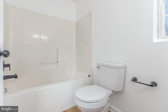 bathroom with bathtub / shower combination and toilet