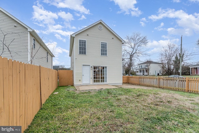 back of property featuring a patio area and a lawn