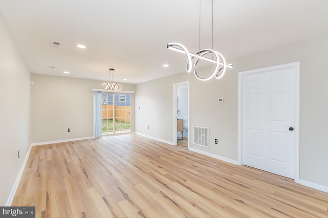 interior space featuring an inviting chandelier and light hardwood / wood-style flooring