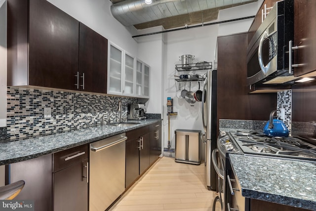 kitchen featuring appliances with stainless steel finishes, sink, dark brown cabinets, and decorative backsplash