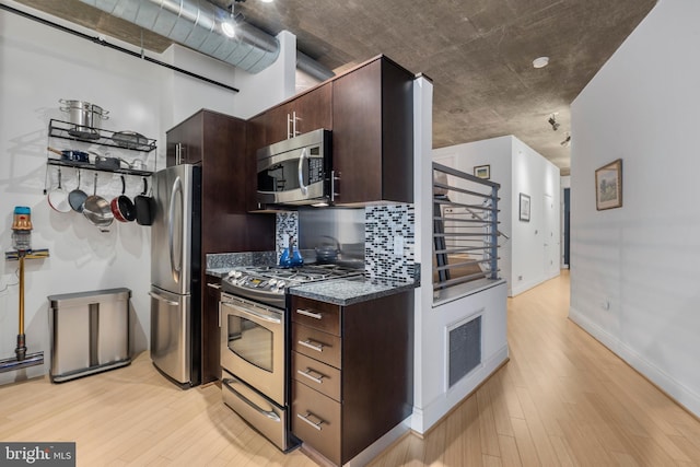 kitchen featuring decorative backsplash, light wood-type flooring, dark brown cabinets, and appliances with stainless steel finishes