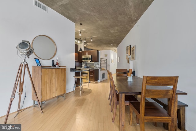 dining area with track lighting and light wood-type flooring