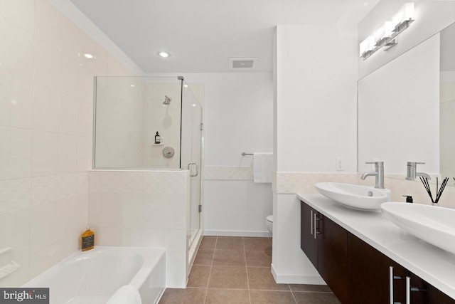 full bathroom with independent shower and bath, vanity, tile patterned floors, and toilet