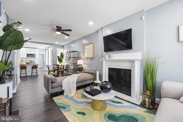 living room featuring dark hardwood / wood-style floors and ceiling fan